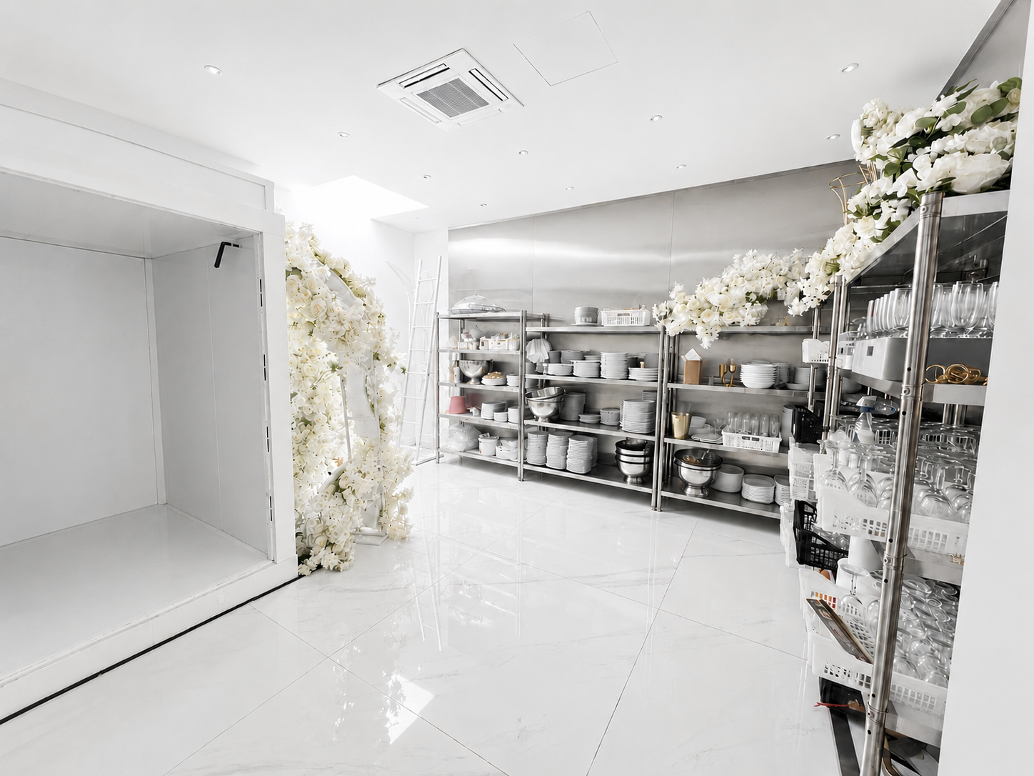 Espace de service Palace Victory Events - Vaisselle blanche et verrerie sur étagères en inox avec compositions florales de roses blanches